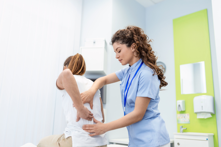Physiotherapist doing healing treatment on womans back back pain patient treatment medical doctor massage therapistoffice syndrome